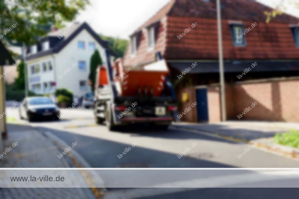 Ein Lastwagen fährt eine schmale Straße entlang.